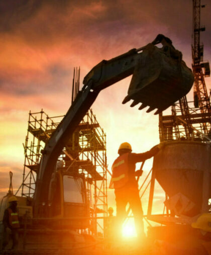 Silhouette Teams of Business Engineers looking for blueprints in construction sites through blurry construction sites at sunset.